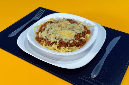 a plate of spaghetti with cheese on a table at Golden Tower Express Anhembi by Fênix Hotéis in Sao Paulo