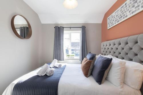 a bedroom with a large bed and a mirror at 4 Bedroom Home with Hot Tub near Gloucester City in Gloucester