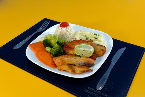 a plate of food with rice and chicken and vegetables at Golden Tower Express Anhembi by Fênix Hotéis in Sao Paulo