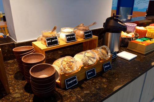 a counter top with a bunch of food in jars at Golden Tower Express Anhembi by Fênix Hotéis in Sao Paulo