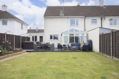 a patio with chairs and a grill in a house at 4 Bedroom Home with Hot Tub near Gloucester City in Gloucester