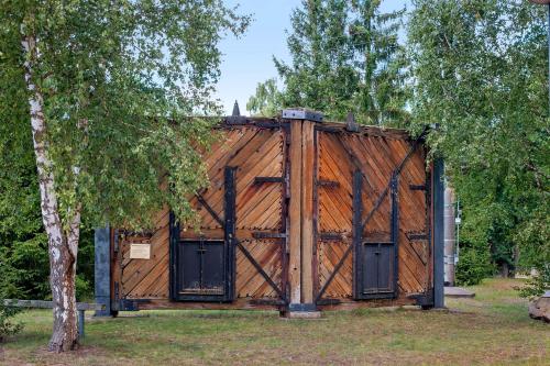 a wooden building with two doors and a tree at Ferienhaus am Rande der Lewitz in Garwitz