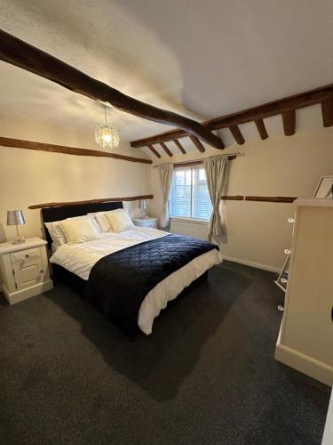 a bedroom with a large bed and a window at Rosemary cottage in Mountnessing