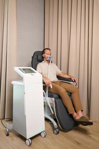 a man sitting in a chair with a mask on at Melea - The Health Concept - Adults Only Hotel in Sárvár