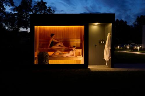 a man and a woman sitting in a hot tub at Melea - The Health Concept - Adults Only Hotel in Sárvár