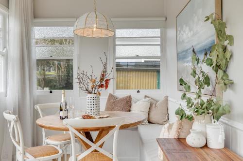 a dining room with a table and a couch at Bluewood Cottage - Cozy Charm, Steps from the City in Toowoomba