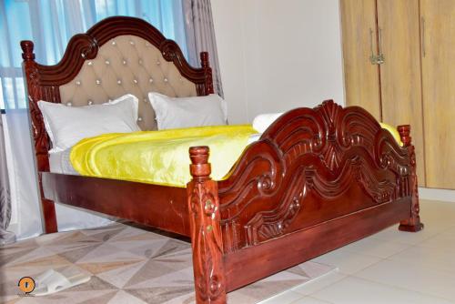 a bed with a wooden frame in a bedroom at Eldoret 3bedroom Apartment in Eldoret