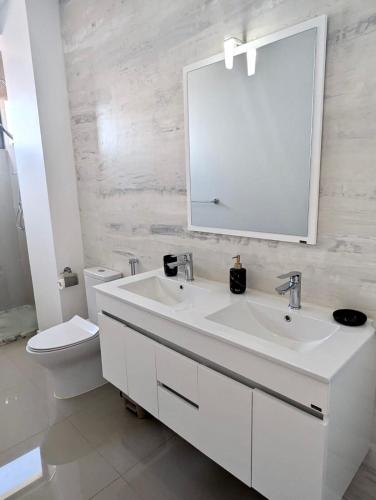 a white bathroom with a sink and a toilet at Casa BB&Djassi - Apartment T2 in Ponta do Sol