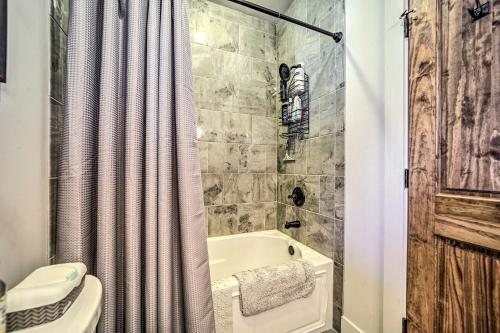 a bathroom with a shower curtain and a tub and a toilet at On 22 Acres Cullowhee Craftsman Home with Mtn Views in Cullowhee