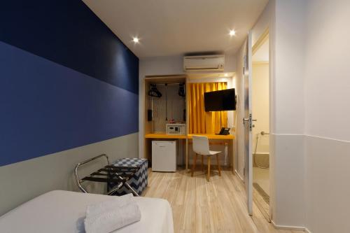 a hotel room with a blue accent wall at Golden Tower Express Anhembi by Fênix Hotéis in Sao Paulo