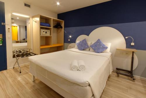 a bedroom with a large white bed with blue walls at Golden Tower Express Anhembi by Fênix Hotéis in Sao Paulo