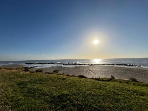 a beach with the sun rising over the ocean at Roma apartamento 2 frente al mar in Mar del Plata