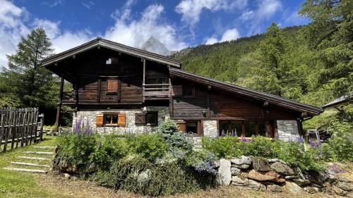a log cabin with mountains in the background at Nos Maisons Cosy - Vallorcine in Vallorcine