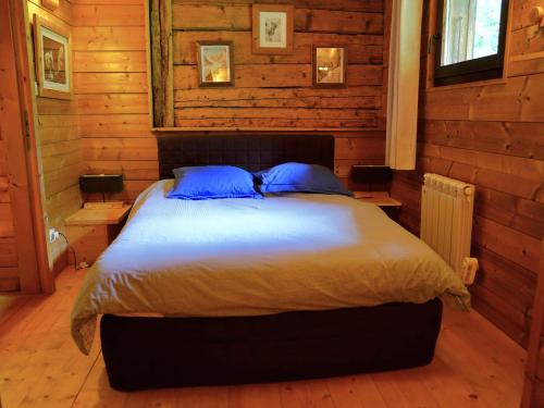 a bedroom with a large bed with blue pillows at Nos Maisons Cosy - Vallorcine in Vallorcine