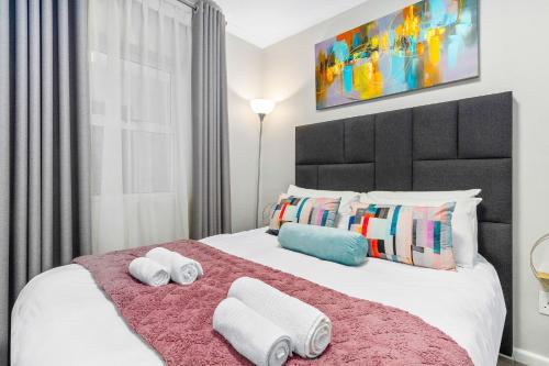 a bedroom with a large bed with towels on it at The Orion 18 by Host Agents in Table View