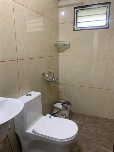 a bathroom with a white toilet and a sink at SatyaYam Park Villa in Cochin