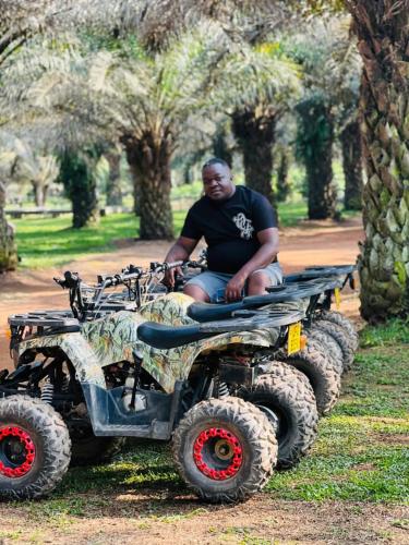 a man sitting on four wheelers in a park at Bugoma Palms Resort Sand Beach 