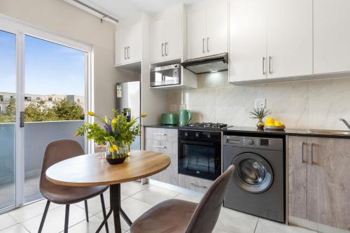 a kitchen with a table and a stove and a sink at The Orion 18 by Host Agents in Table View