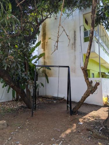 a swing set in front of a building at SatyaYam Park Villa in Cochin
