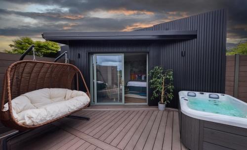 a wicker chair sitting on a deck next to a tub at Bellinter House Hotel & Spa in Navan