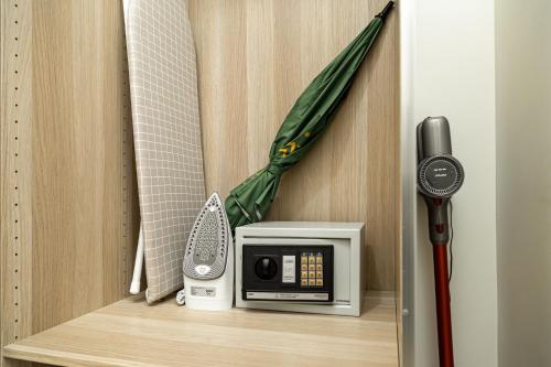 a room with a microwave and an umbrella at Calypso Garden Residences by Beringela in Phuket Town