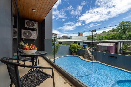 a balcony with a plunge pool and a table and chairs at Calypso Garden Residences by Beringela in Phuket Town