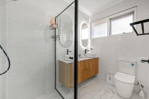 Un baño con ducha, inodoro y lavabo. en Beautiful and cozy home, en Glenunga
