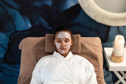 a man with sunscreen on his face sitting in a chair at The Plettenberg Hotel in Plettenberg Bay