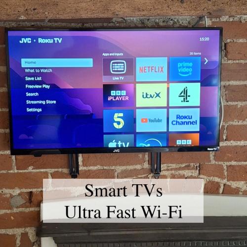 a flat screen tv hanging on a brick wall at The Abbey Hotel & Apartments in Bury Saint Edmunds