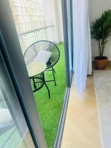 a chair sitting on the grass outside a window at TheEJResidence- 2Bedroom All Ensuite- 7km from JKIA 3km from SGR and Expressway along Mombasa Road-Nairobi Kenya in Nairobi