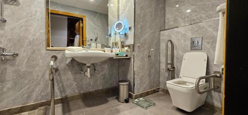 a bathroom with a sink and a toilet and a mirror at Jiwar Al Saha Hotel in Al Madinah