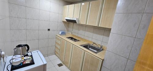 a small kitchen with a sink and a counter at Jiwar Al Saha Hotel in Al Madinah