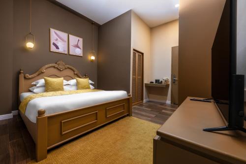 a bedroom with a bed and a flat screen tv at Ali Grand Hotel in Vientiane