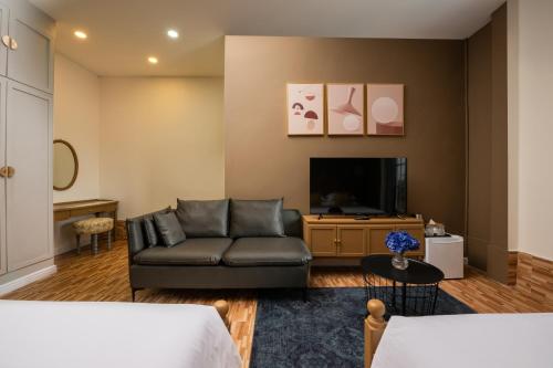 a living room with a couch and a tv at Ali Grand Hotel in Vientiane