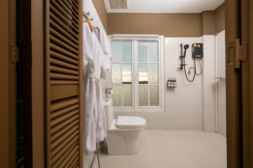 a bathroom with a toilet and a window at Ali Grand Hotel in Vientiane