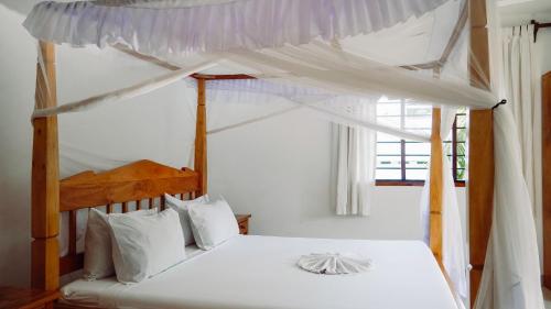 Postel nebo postele na pokoji v ubytování Parrot Bay Watamu