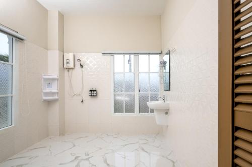 a white bathroom with a sink and a window at Ali Grand Hotel in Vientiane
