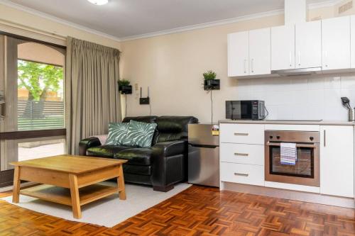 una cucina e un soggiorno con divano e tavolo di Compact and Convenient Unit - Hosted by Canstay a Canberra