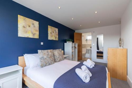 a bedroom with a bed with towels on it at Modern & Spacious Home in Central Cheltenham in Gloucestershire