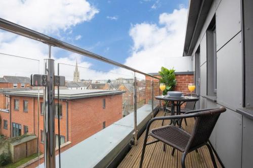 a balcony with a table and a view of a city at Modern & Spacious Home in Central Cheltenham in Gloucestershire