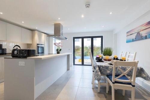 a kitchen and dining room with a table and chairs at Modern & Spacious Home in Central Cheltenham in Gloucestershire