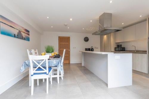 a kitchen with a table and chairs in a room at Modern & Spacious Home in Central Cheltenham in Gloucestershire