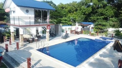 a large swimming pool in front of a house at Baylosis Resort in Calatagan