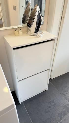 a white dresser with shoes sitting on top of it at Bloom Apartment in Pero