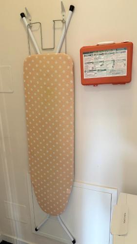 a surfboard hanging on a wall next to a clipboard at Bloom Apartment in Pero