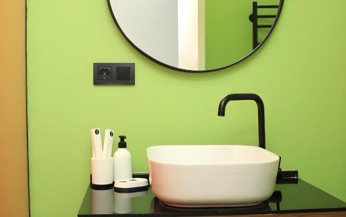 a bathroom with a white sink and a mirror at Rooms Apart Hotel by RED in Yerevan