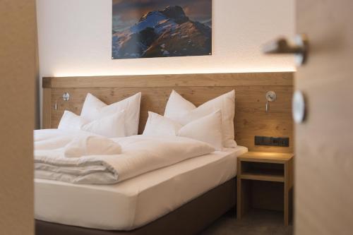 a bedroom with a bed with white pillows at Anthony's Peaks & Pillows in Sankt Anton am Arlberg