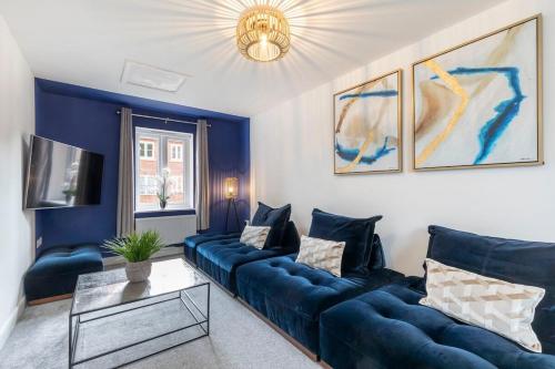 a living room with a blue couch and a table at Stunning 4 Bed 3 Bathroom Home in Gloucestershire