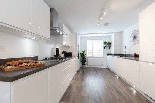 a kitchen with white cabinets and a counter top at Modern 4 Bed 3 Bath Home Close to the Town Centre in Gloucestershire