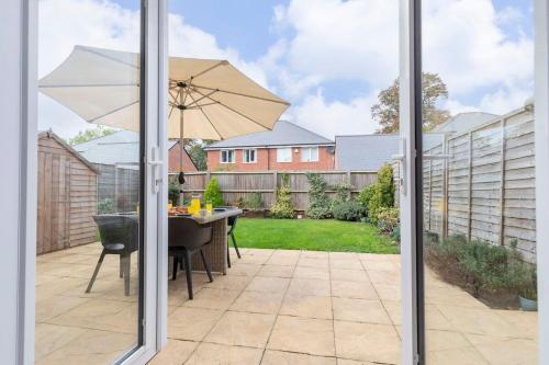 a patio with a table and an umbrella at Modern 4 Bed 3 Bath Home Close to the Town Centre in Gloucestershire